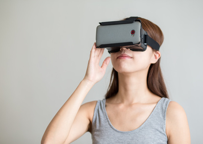 Young woman with hand holding virtual reality device
